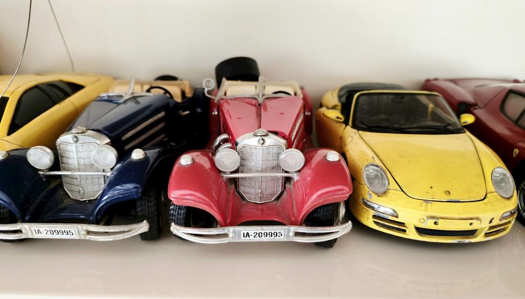 Leksaksbilar i olika färger: blå, röd och gul, tätt packade på en hylla.